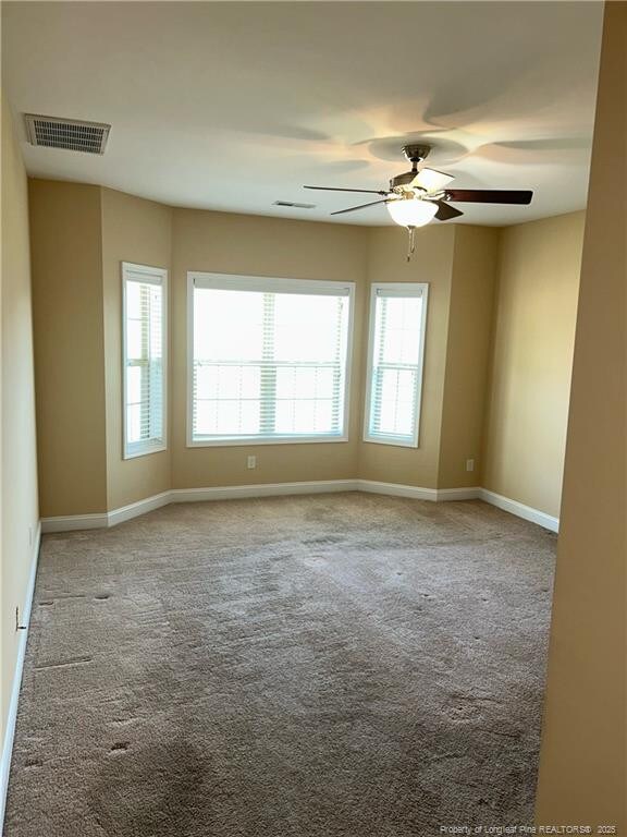 6605 Stillwood Dr, Hope Mills, NC 28348 - carpeted spare room with baseboards, visible vents, and a ceiling fan