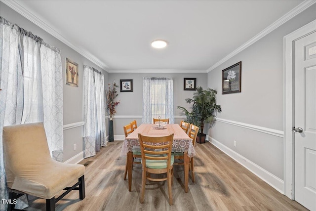 dining area with light hardwood / wood-style floors and crown molding