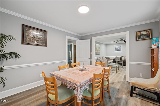 dining area featuring wood-type flooring, ceiling fan, and crown molding