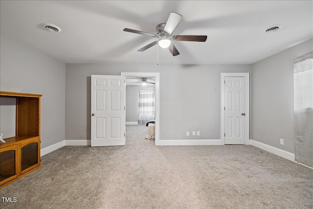 unfurnished bedroom with light colored carpet and ceiling fan