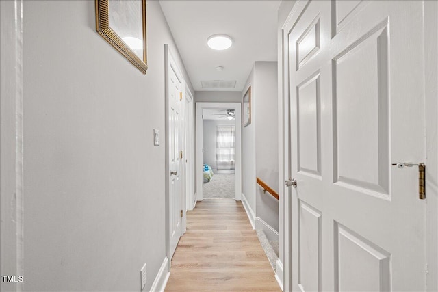 hallway with light hardwood / wood-style floors