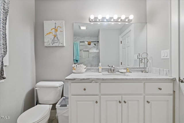 bathroom with toilet, vanity, and walk in shower