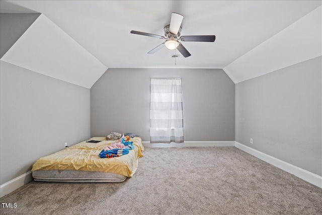 carpeted bedroom with ceiling fan and vaulted ceiling