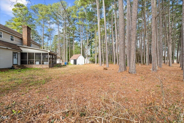 view of yard featuring a shed and a sunroom