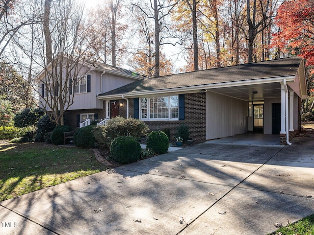 tri-level home with a front lawn and a carport