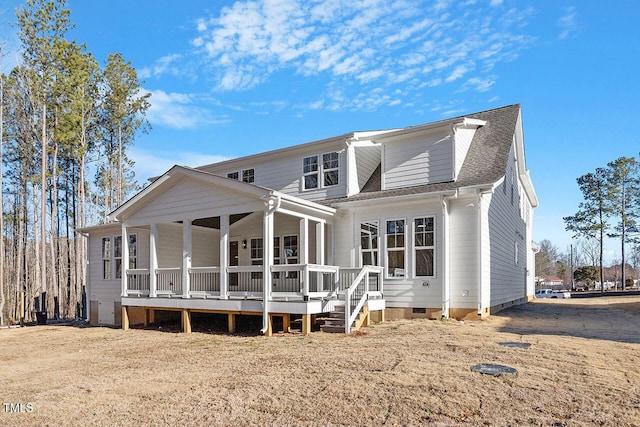 rear view of house with covered porch and a lawn