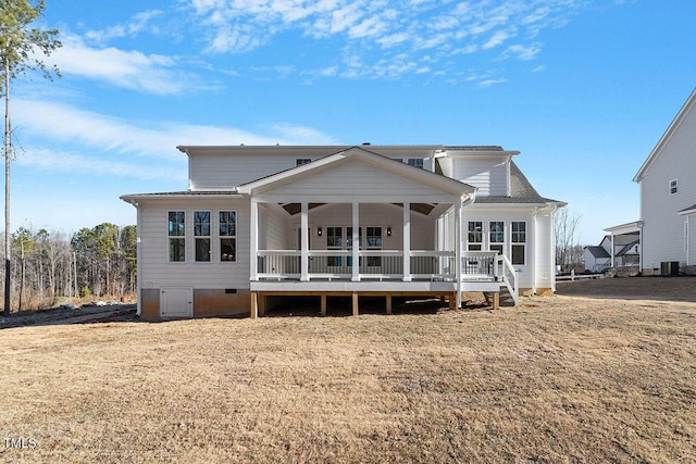 back of house with cooling unit and a yard