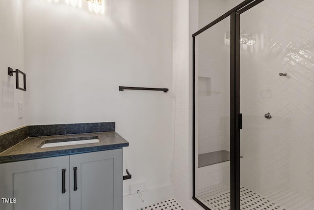 bathroom with a shower with shower door and vanity