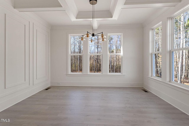 unfurnished dining area with light hardwood / wood-style flooring, beam ceiling, a notable chandelier, and coffered ceiling