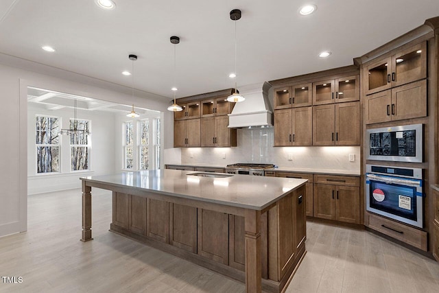 kitchen featuring stainless steel oven, built in microwave, a spacious island, and pendant lighting