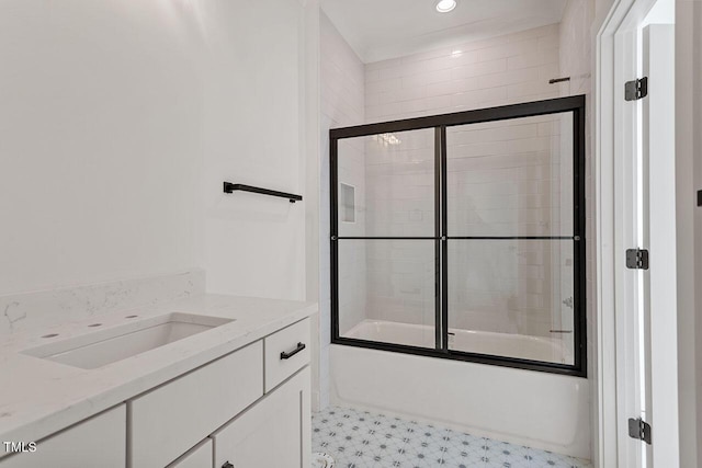 bathroom featuring combined bath / shower with glass door and vanity