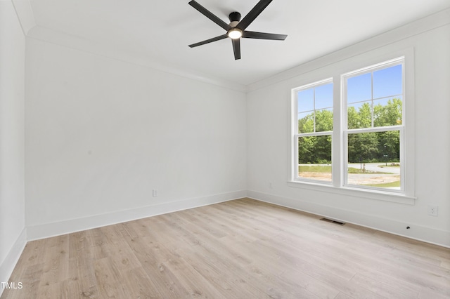 unfurnished room featuring light wood finished floors, a ceiling fan, baseboards, and crown molding