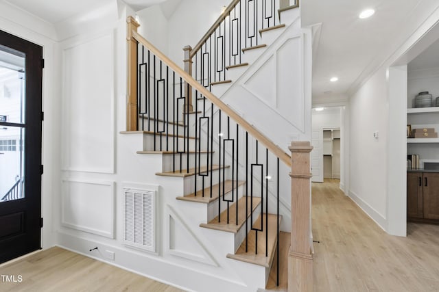 foyer entrance featuring wood finished floors, stairs, recessed lighting, crown molding, and baseboards