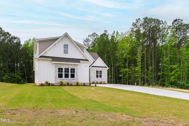 modern farmhouse style home featuring board and batten siding, a front yard, and concrete driveway