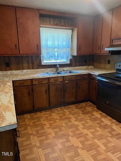 kitchen featuring sink, black range with electric cooktop, extractor fan, a textured ceiling, and light parquet flooring