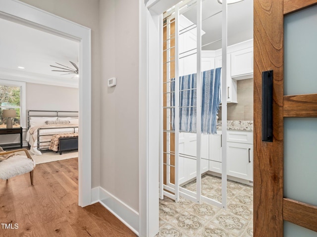 bathroom with wood-type flooring, ceiling fan, and ornamental molding