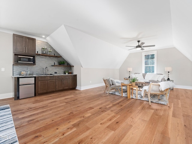 living room featuring ceiling fan, sink, and light wood-type flooring