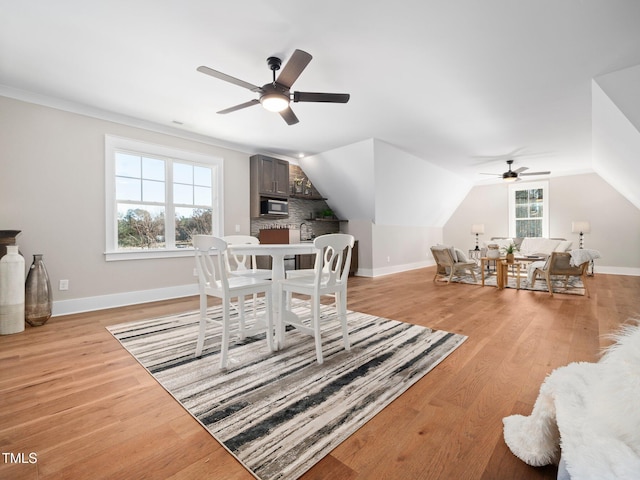 dining room with light hardwood / wood-style flooring, ceiling fan, and lofted ceiling