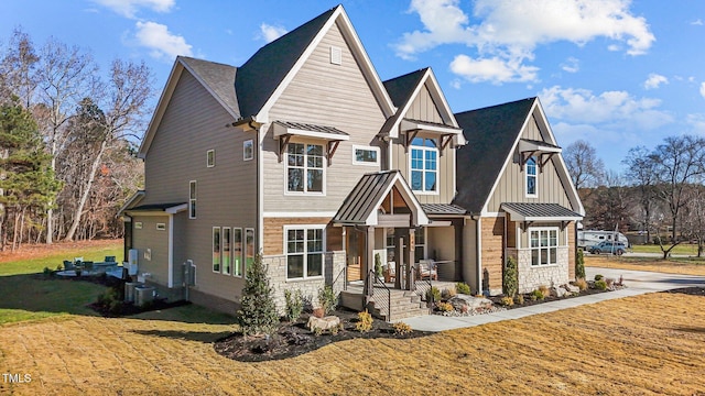145 Wiggins Rd, Louisburg, NC 27549 - view of front of home with a front yard, board and batten siding, a porch, a standing seam roof, and stone siding