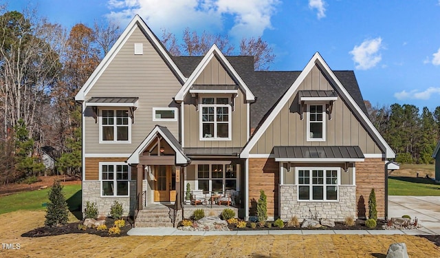 145 Wiggins Rd, Louisburg, NC 27549 - view of front of house with stone siding, a standing seam roof, board and batten siding, and a metal roof