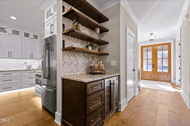 145 Wiggins Rd, Louisburg, NC 27549 - kitchen with wine cooler, high end fridge, dark brown cabinets, white cabinetry, and ornamental molding