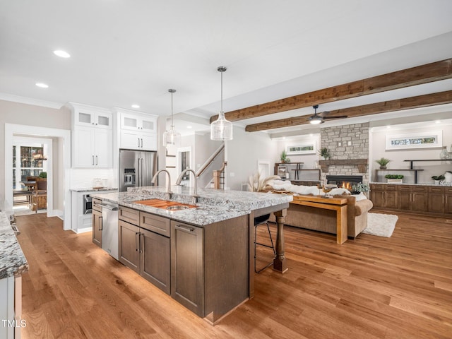 145 Wiggins Rd, Louisburg, NC 27549 - kitchen featuring appliances with stainless steel finishes, light wood-type flooring, a fireplace, white cabinets, and recessed lighting