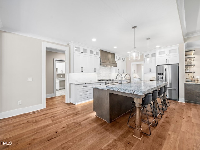 145 Wiggins Rd, Louisburg, NC 27549 - kitchen with stainless steel refrigerator with ice dispenser, custom exhaust hood, recessed lighting, backsplash, and a kitchen breakfast bar