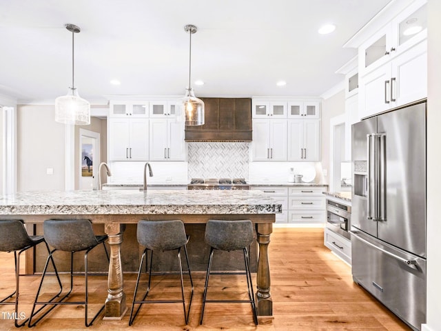 145 Wiggins Rd, Louisburg, NC 27549 - kitchen featuring high end fridge, premium range hood, decorative backsplash, a breakfast bar, and white cabinets