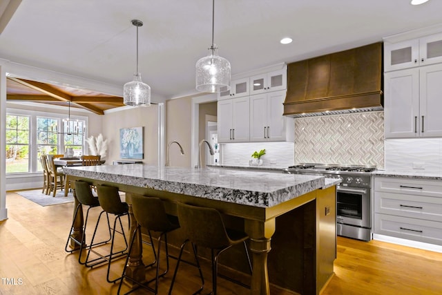 145 Wiggins Rd, Louisburg, NC 27549 - kitchen featuring custom exhaust hood, stainless steel gas range, recessed lighting, an island with sink, and tasteful backsplash