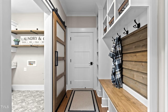 mudroom with a barn door and ornamental molding