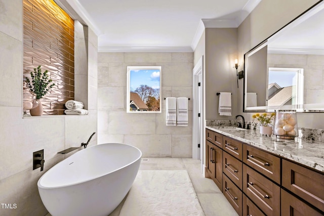 bathroom featuring a tub, tile patterned floors, vanity, tile walls, and ornamental molding