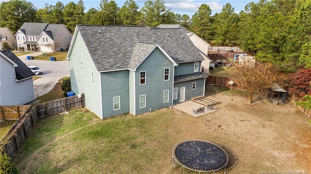 rear view of property featuring a lawn and a patio area