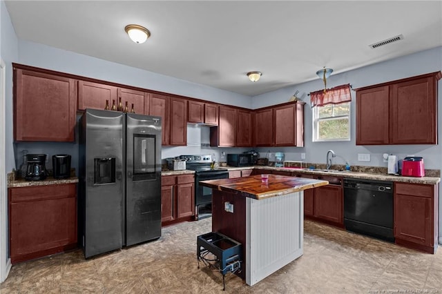 kitchen with black appliances, a kitchen island, sink, and hanging light fixtures