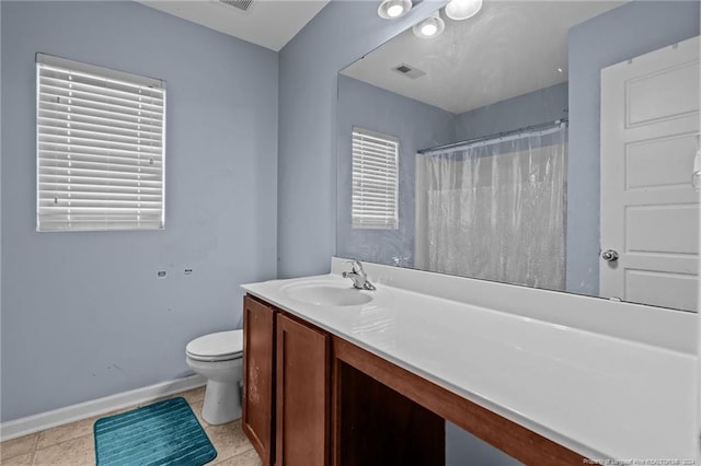 bathroom with tile patterned flooring, vanity, a healthy amount of sunlight, and toilet