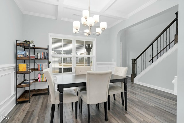 dining space with hardwood / wood-style floors, an inviting chandelier, ornamental molding, and coffered ceiling