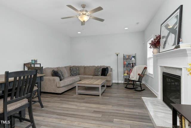 living room featuring a premium fireplace, ceiling fan, and hardwood / wood-style flooring