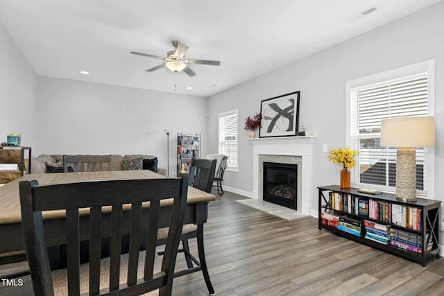 dining space with a wealth of natural light, hardwood / wood-style floors, and ceiling fan