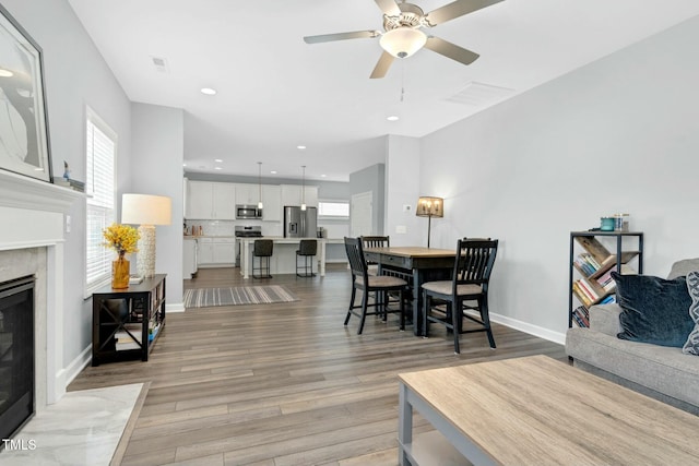 dining space with ceiling fan and light hardwood / wood-style flooring