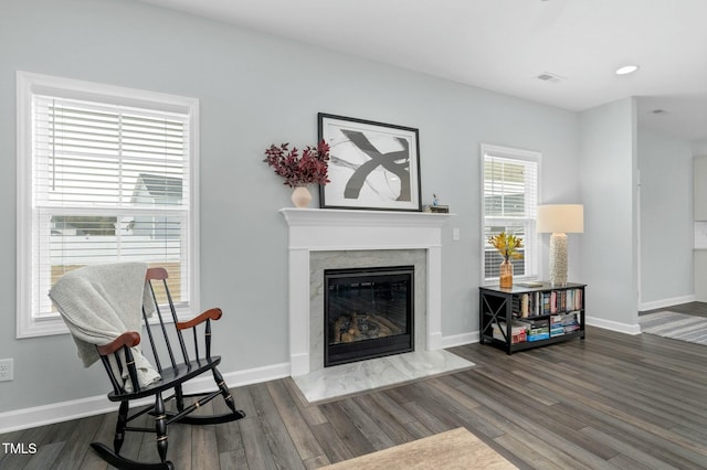 living area with a high end fireplace and dark wood-type flooring