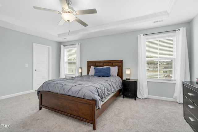 bedroom featuring a raised ceiling, ceiling fan, light colored carpet, and ornamental molding