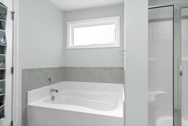 bathroom featuring shower with separate bathtub