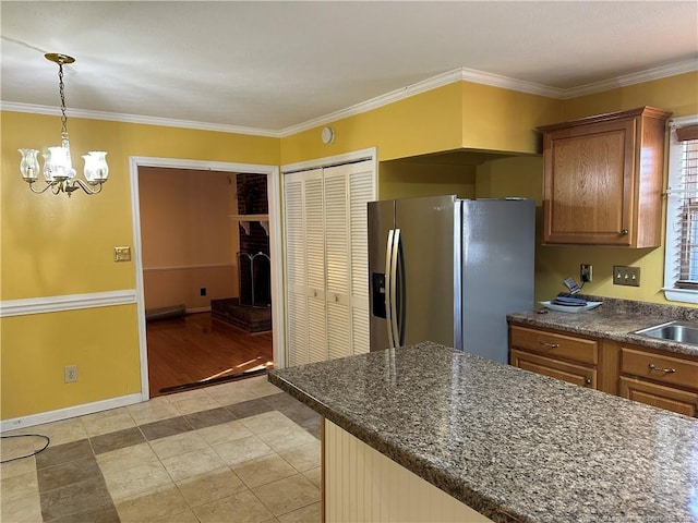 kitchen featuring brown cabinetry, decorative light fixtures, crown molding, and a fireplace