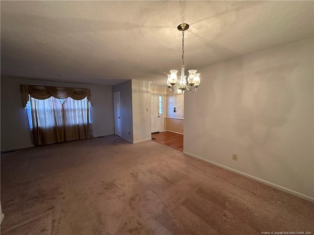 interior space with a textured ceiling, baseboards, a notable chandelier, and a healthy amount of sunlight