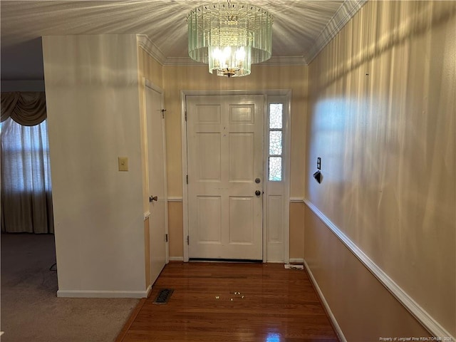 doorway featuring crown molding, visible vents, a notable chandelier, and wood finished floors