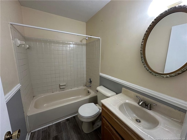 bathroom with toilet, tub / shower combination, wood finished floors, and vanity