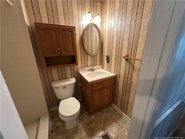 bathroom with visible vents, wallpapered walls, toilet, vanity, and tile patterned floors