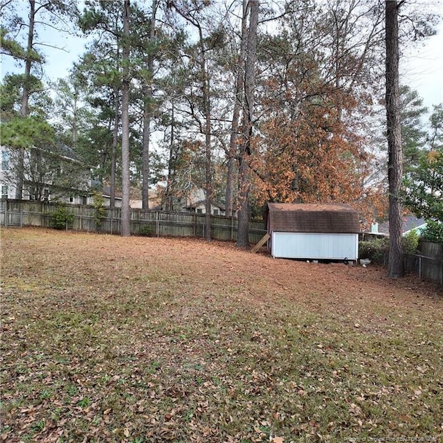 view of yard featuring a storage shed, an outbuilding, and a fenced backyard