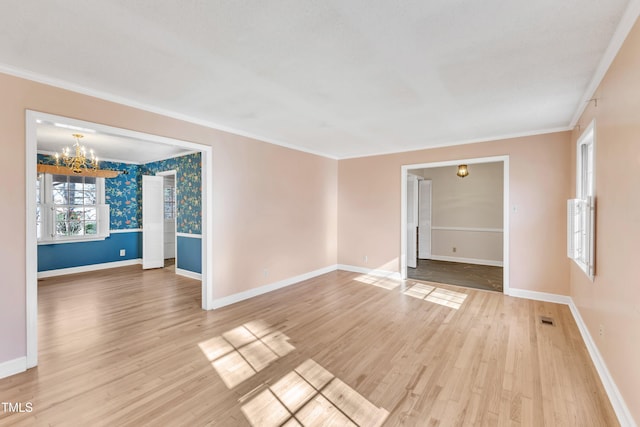 spare room featuring hardwood / wood-style floors, a notable chandelier, and crown molding