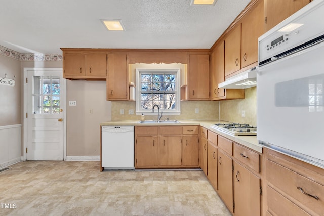 kitchen featuring decorative backsplash, a textured ceiling, white appliances, and sink