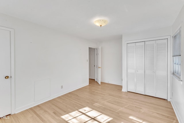 unfurnished bedroom featuring light wood-type flooring and a closet